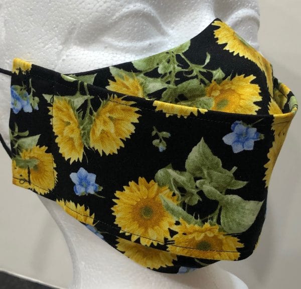 Large yellow and tiny blue flowers on black mask